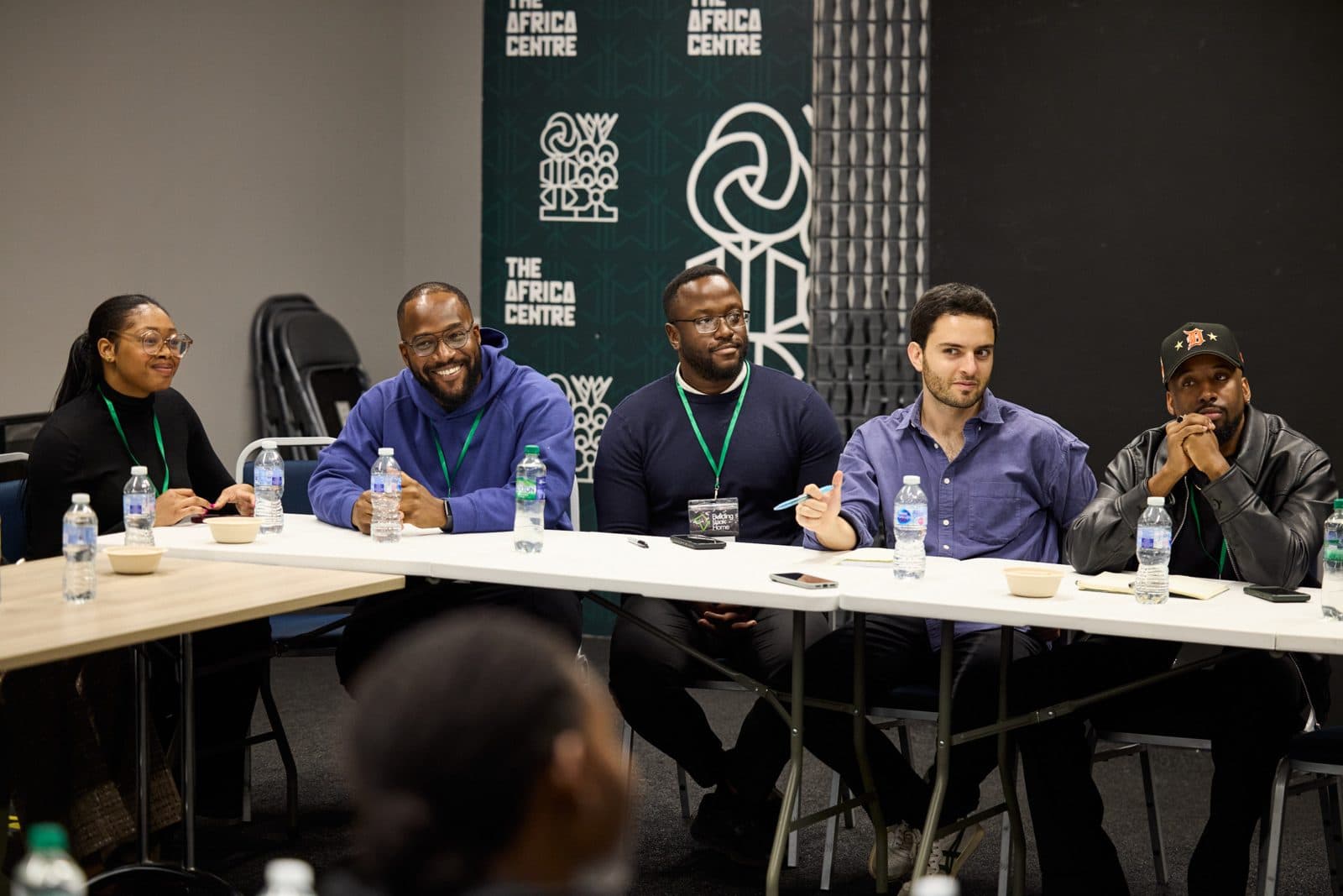 A panel of speakers seated at a long table